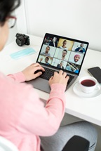 A person on a virtual call with others on a laptop