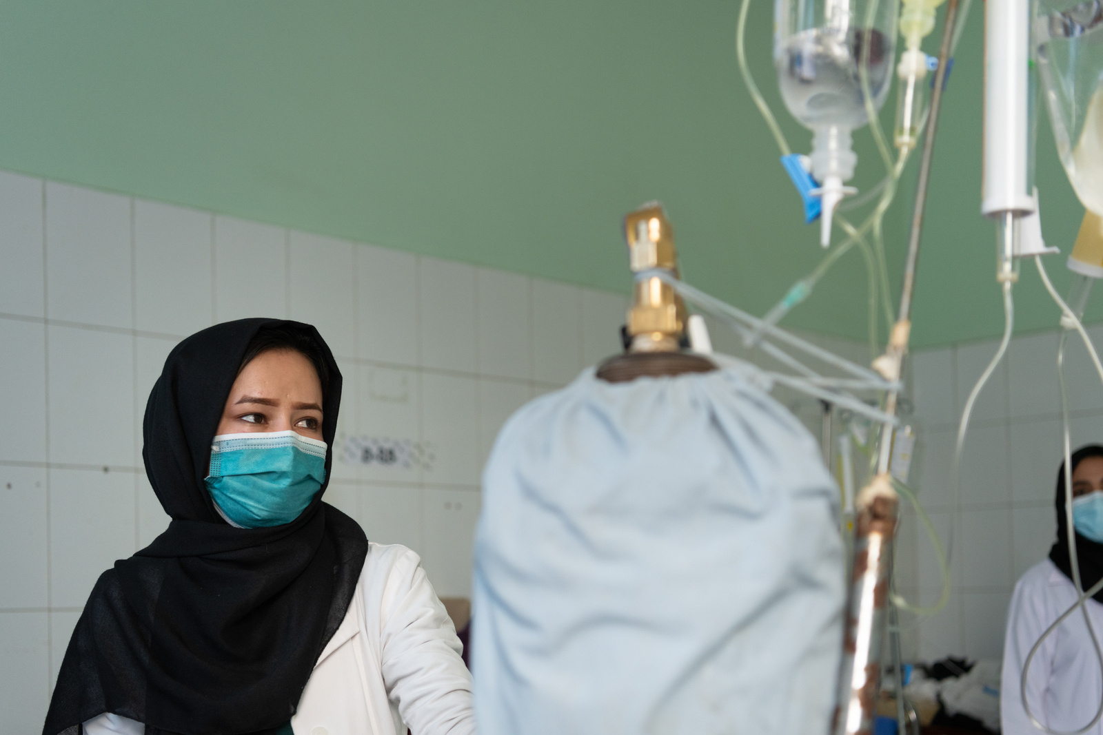 A health worker in a hospital in Afghanistan, next to oxygen cylinders