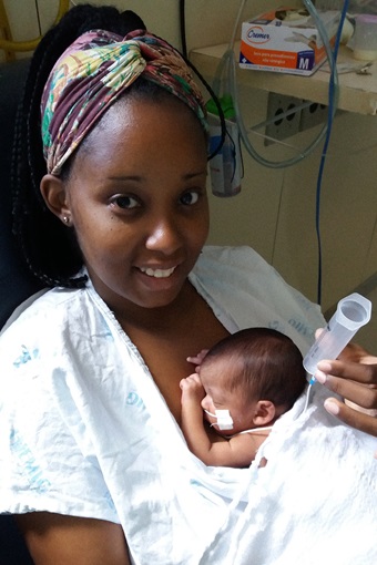 A mother holds a newborn preterm baby on her chest, in Brazil