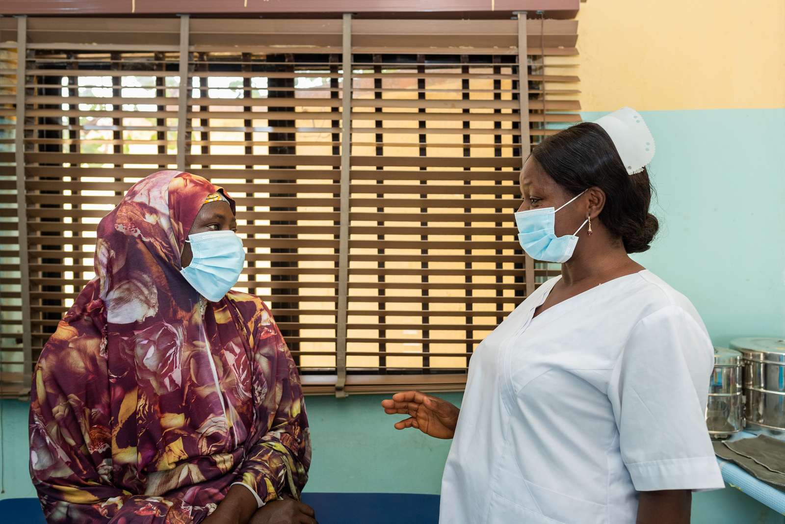 Nurse Peace (right) counsels a patient before she gets screened for cervical cancer at the RAiSE Foundation office in Niger State on 24 February 2021.