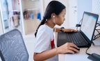 Indonesian girl learning with laptop and earphone at home