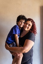 A child held by his mother in her arms, in Argentina