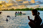 A girl against water, where children are swimming in Kiribati