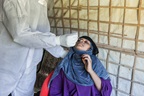 A Rohinhya woman gets tested for COVID-19 via nasal swab by a healthcare professional, in Cox's Bazar, Ban