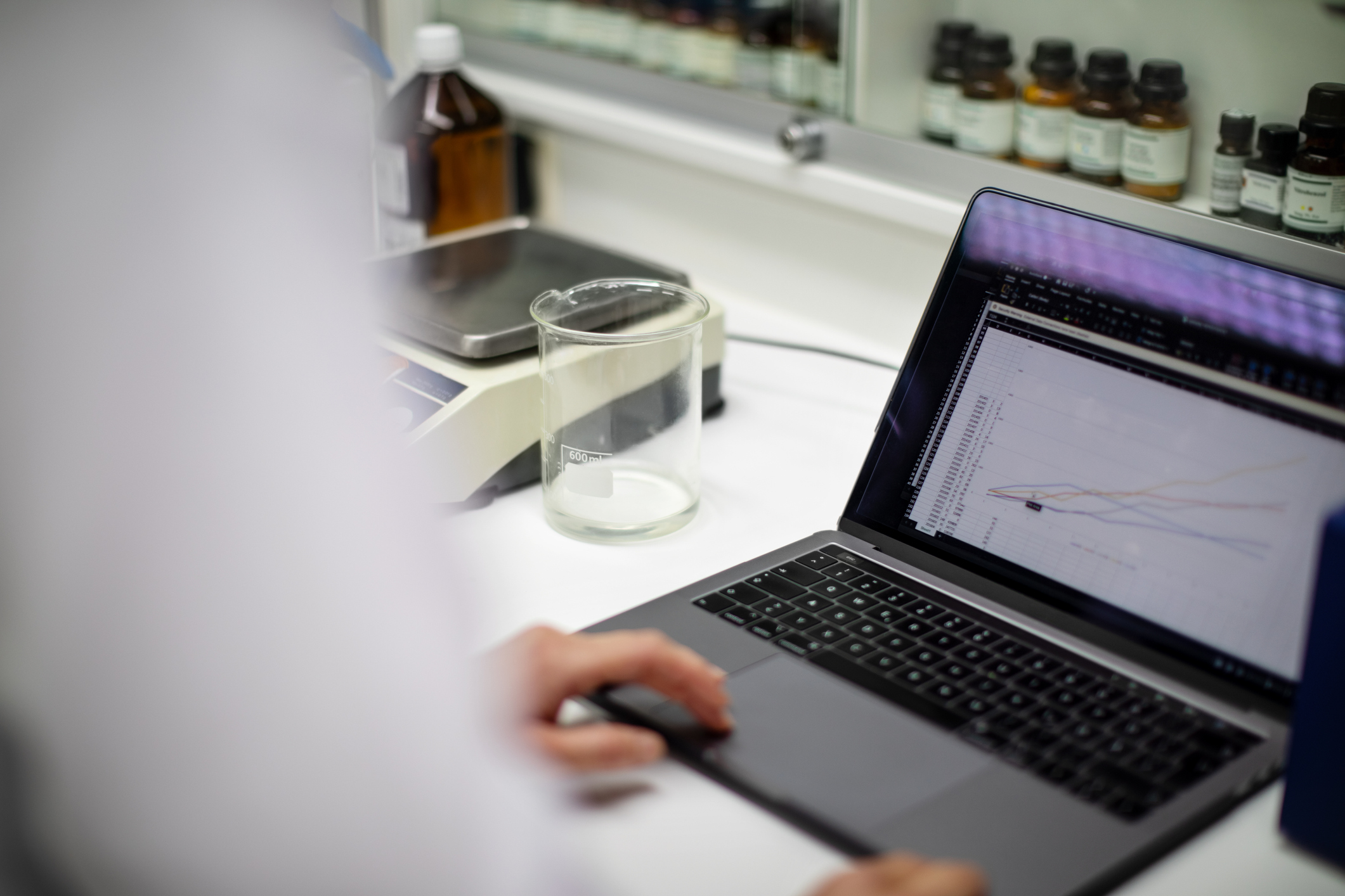 Close-up of a female scientist analyzing experimental results on a laptop in a laboratory