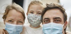 Family taking a selfie together while wearing protective face masks, in Spain
