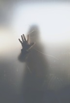 Person standing behind glass window