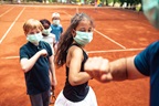 Close up of a group of kids elbow bumping their tennis instructor after practice, in Belgrade, Serbia