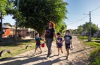 A mother walking with three children, all wearing face masks due to COVID-19 in Moreno, Argentina