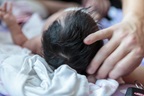 Midwife feels skull of a three-week old baby, in Canada
