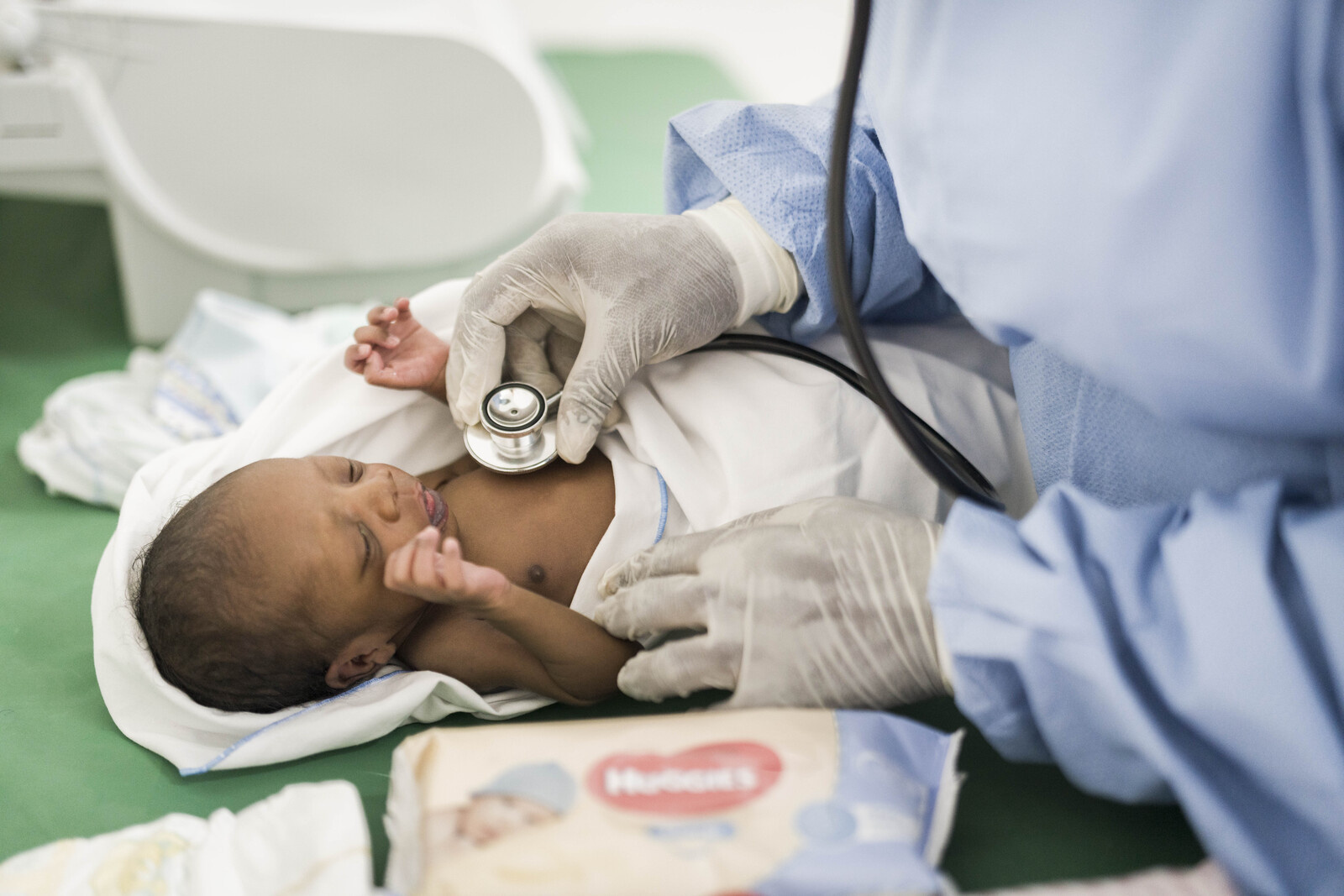A doctor listens to a newborn's chest with a statoscope in Accra, Ghana