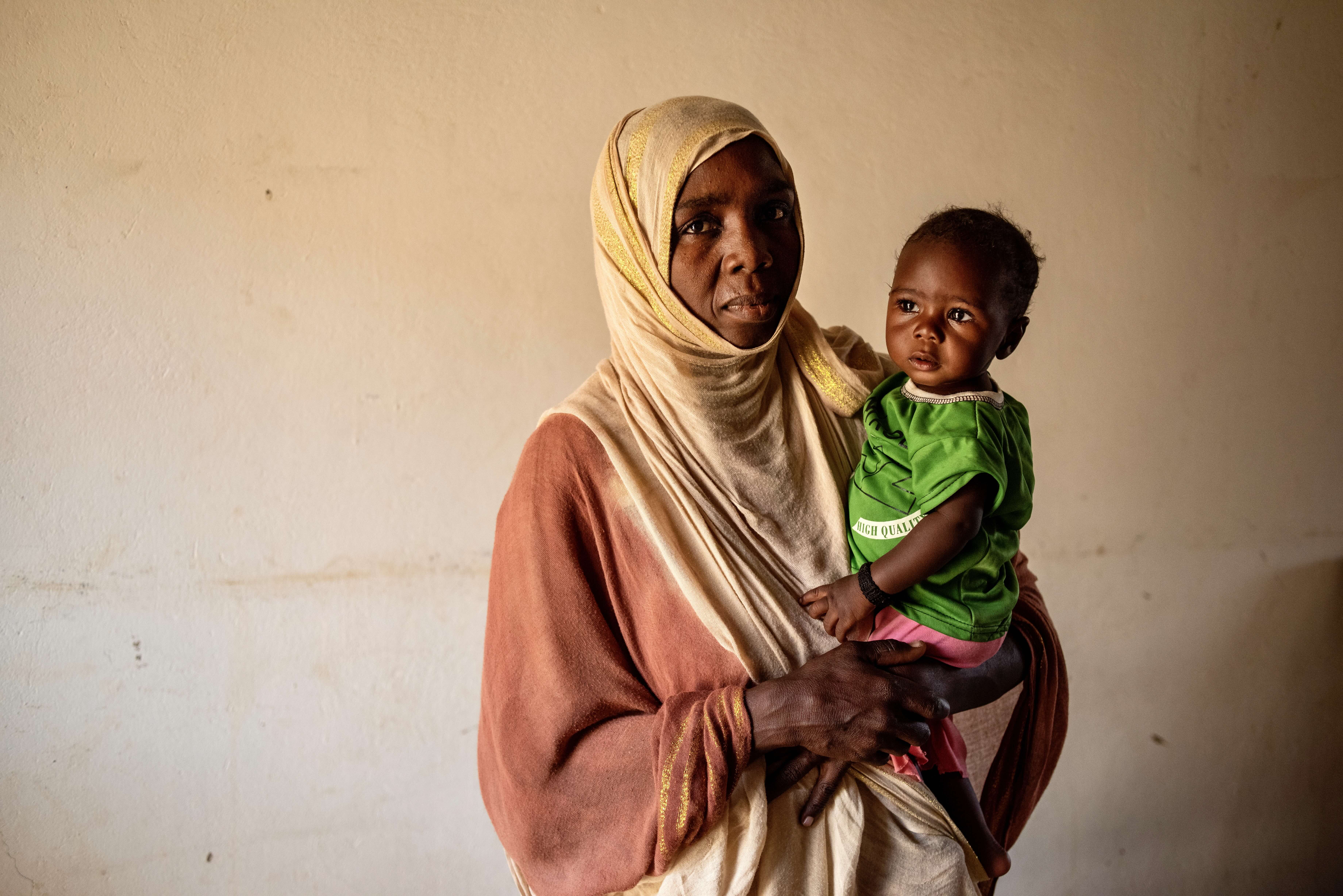 A mother holding her young child in North Darfur, Sudan