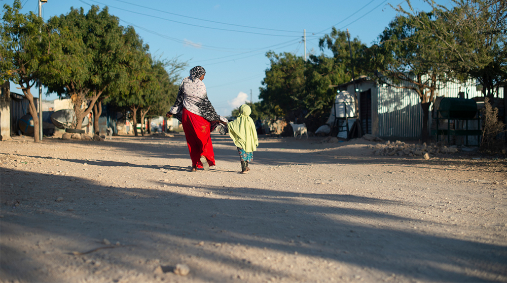 A woman and child walk on streets in Somalia