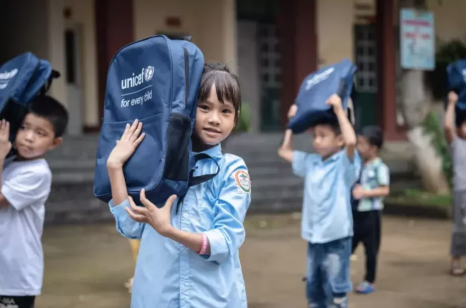 Children carry UNICEF bags on their heads
