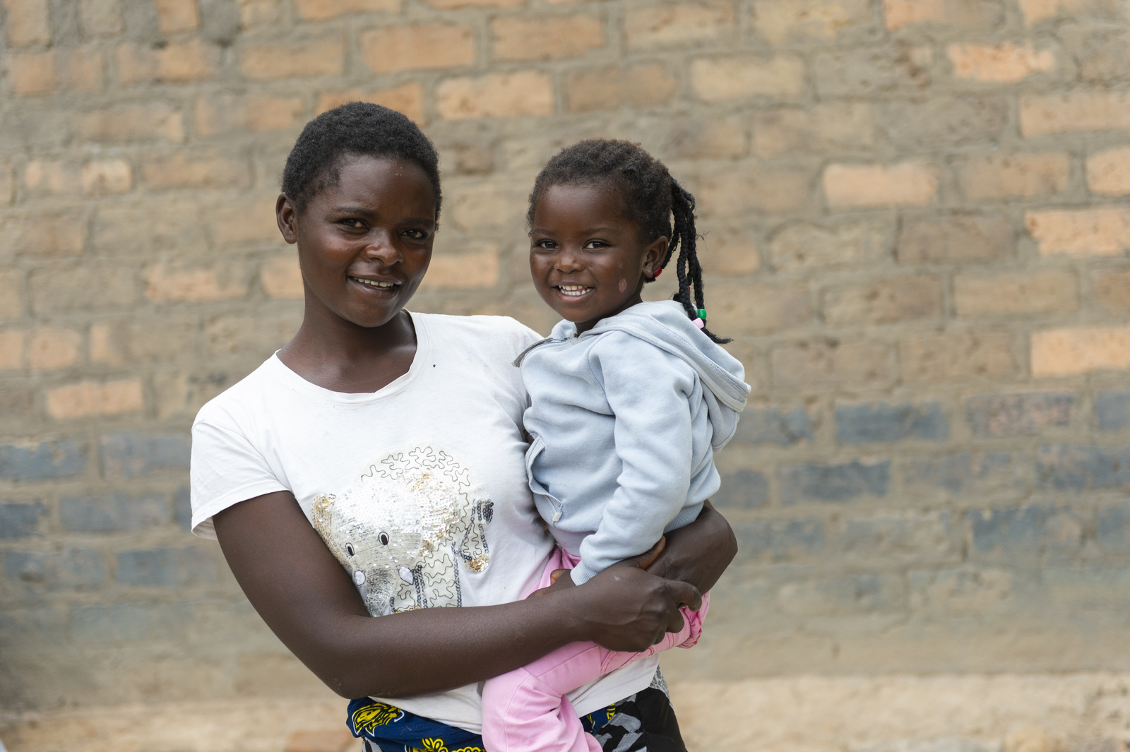 A mother holding her daughter on her hip, in Zambia